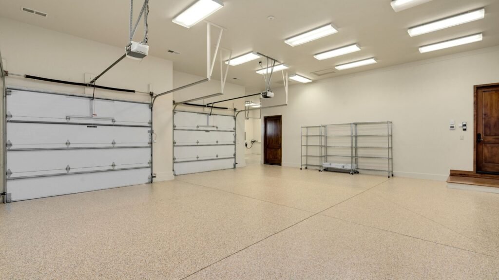 Clean three-car garage with two sectional doors and ceiling-mounted openers