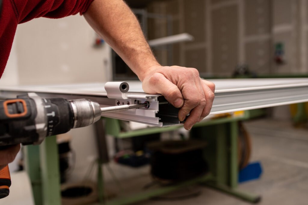 Technician fastening hardware to a garage door panel with a drill