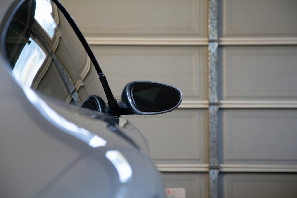 Car parked inside a garage in front of a closed sectional door