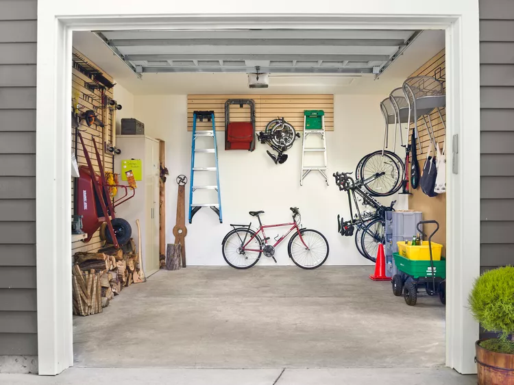 Organized residential garage with bicycles, ladders, tools, and storage equipment