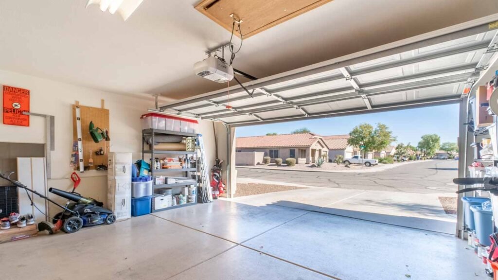 Open residential garage with a ceiling-mounted opener and storage shelves